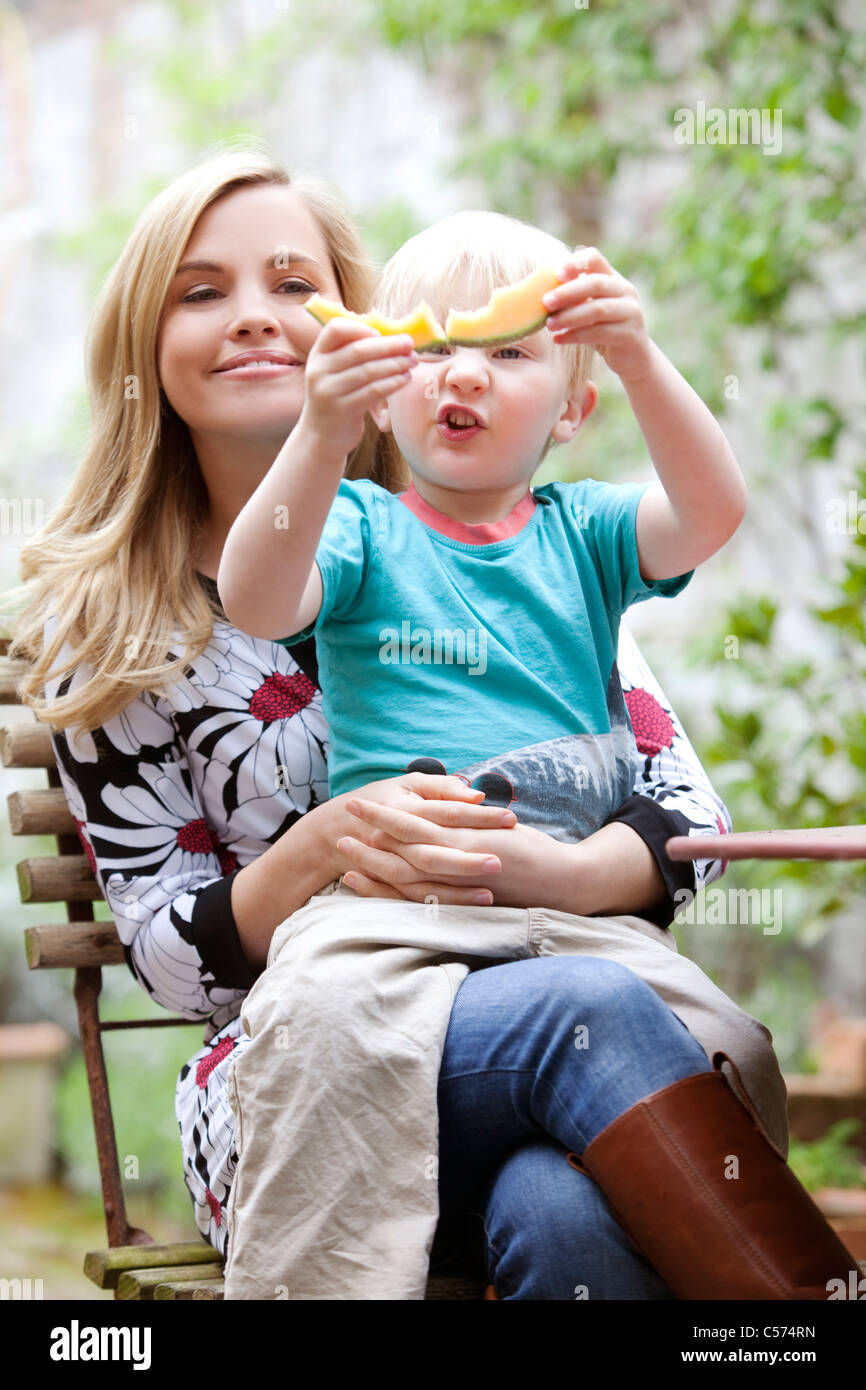 Mutter Sohn Holding mit Scheibe Melone Stockfoto