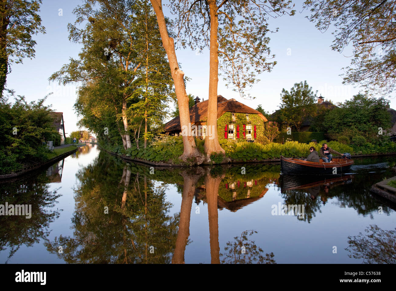 Die Niederlande, Giethoorn, Dorf mit fast nur Wasserstraßen. Touristen genießen Bootsfahrt. Stockfoto