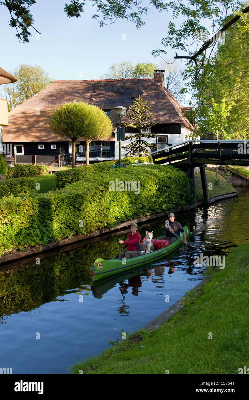 Die Niederlande, Giethoorn, Dorf mit fast nur Wasserstraßen. Touristen genießen Kajakfahrt. Stockfoto