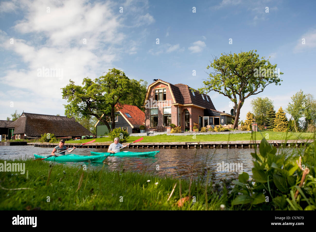 Die Niederlande, Giethoorn, Dorf mit fast nur Wasserstraßen. Touristen genießen Kajakfahrt. Stockfoto