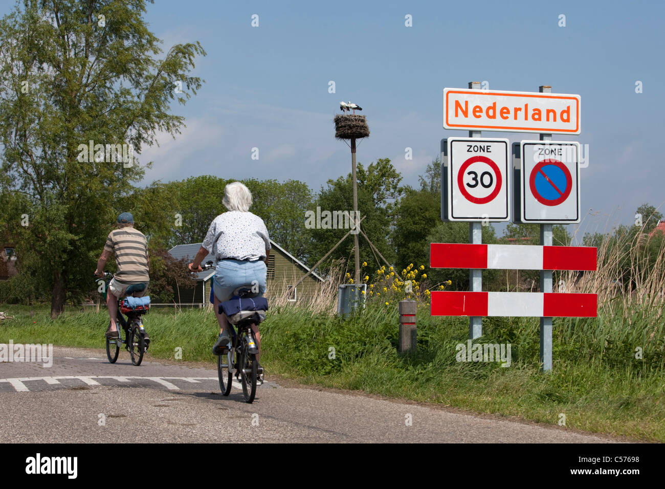 Niederlande, Nederland, Dorf namens Nederland, d.h. Niederlande in niederländischer Sprache. Älteres paar Radfahren. Stockfoto