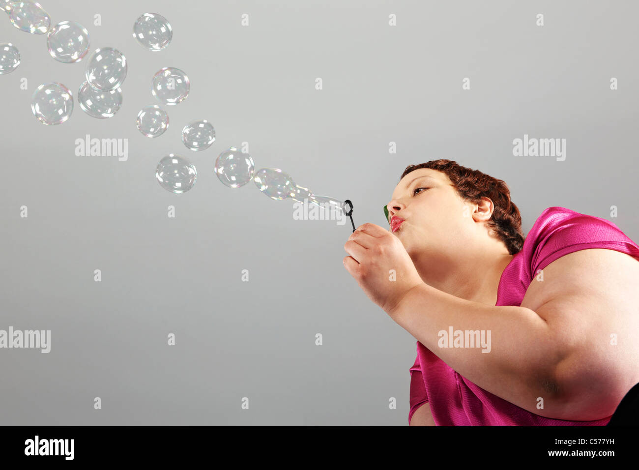 Große Frau blowing bubbles Stockfoto
