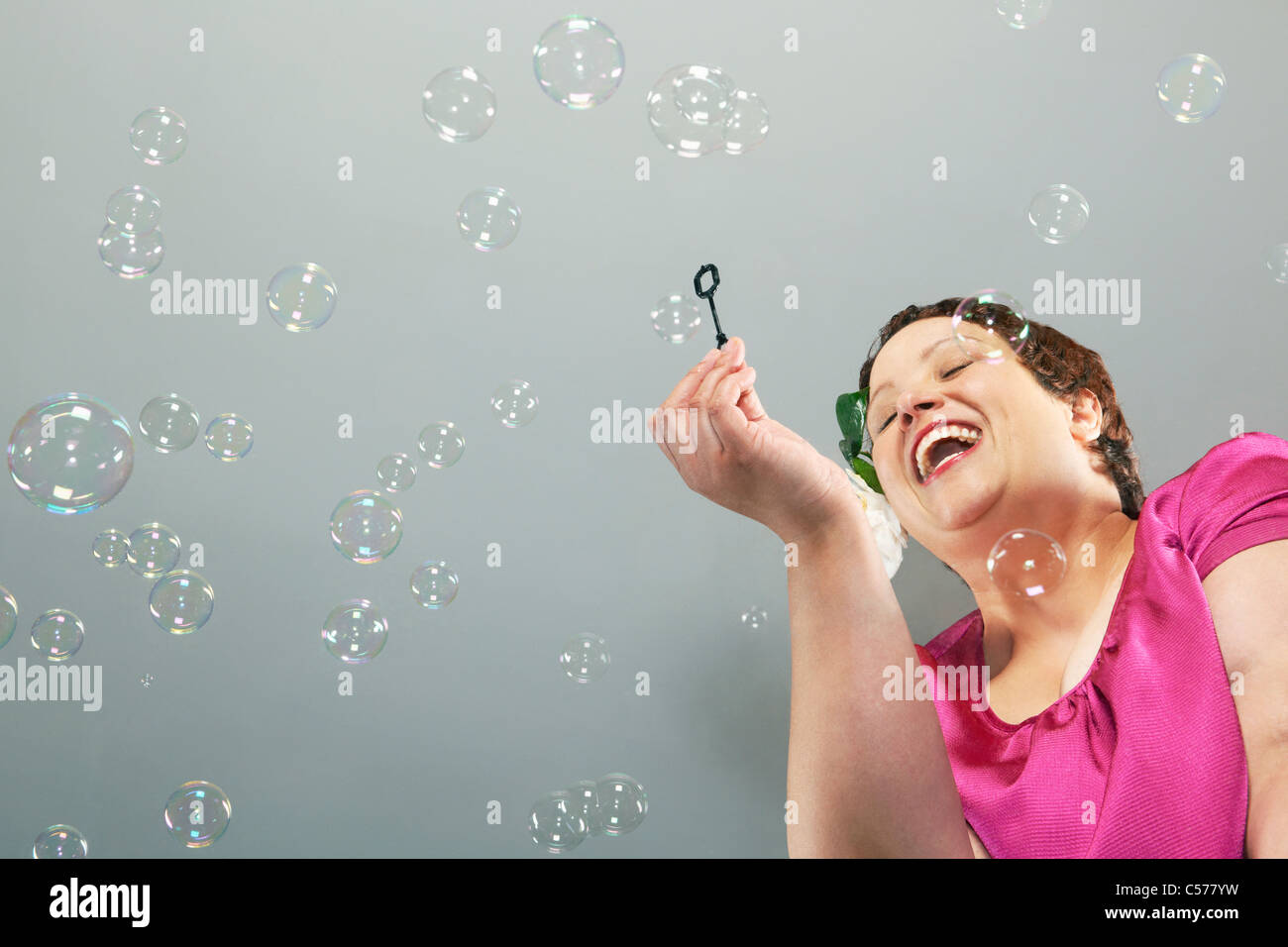 Große Frau blowing bubbles Stockfoto