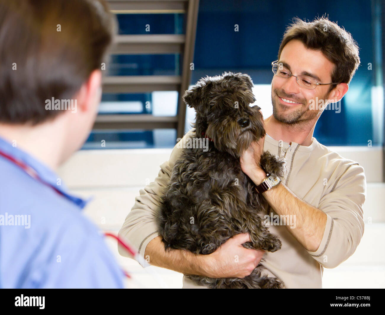 Mann halten Hund beim Tierarzt Stockfoto