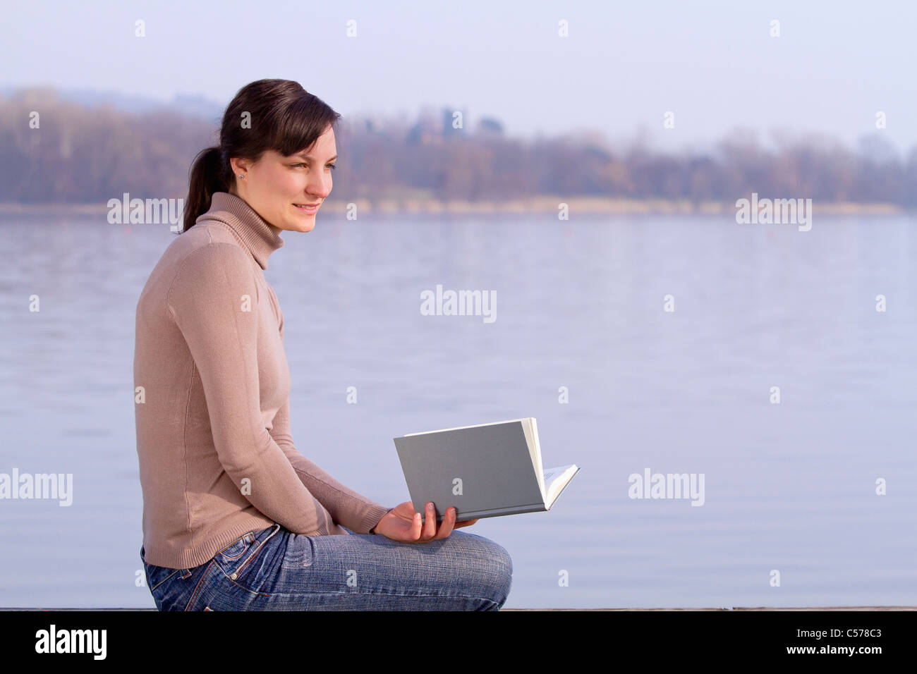 Frau mit Buch im Freien sitzen Stockfoto