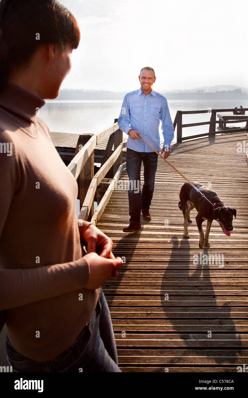 Paar walking Hund auf pier Stockfoto