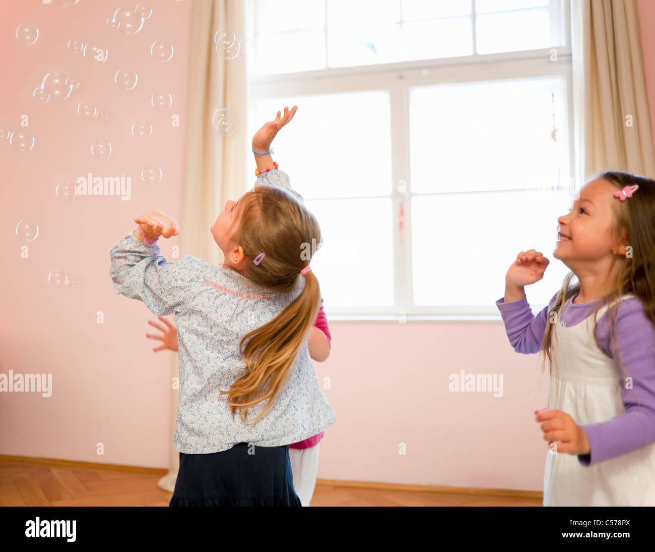Mädchen spielen mit Luftblasen zusammen Stockfoto