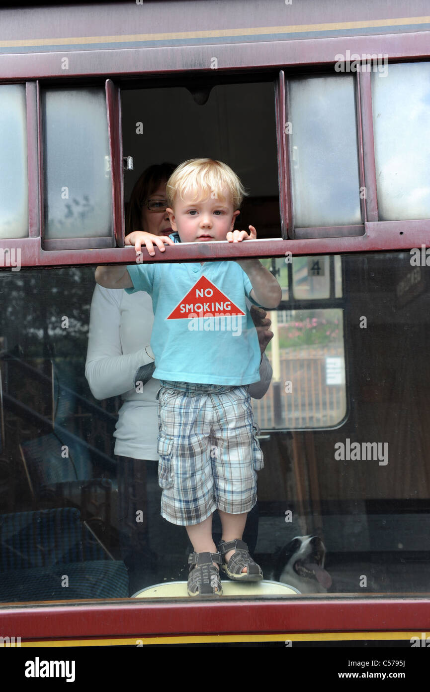 Kleiner Junge spähte durch die Fenster der Dampflokomotive auf Severn Valley Railway uk Stockfoto
