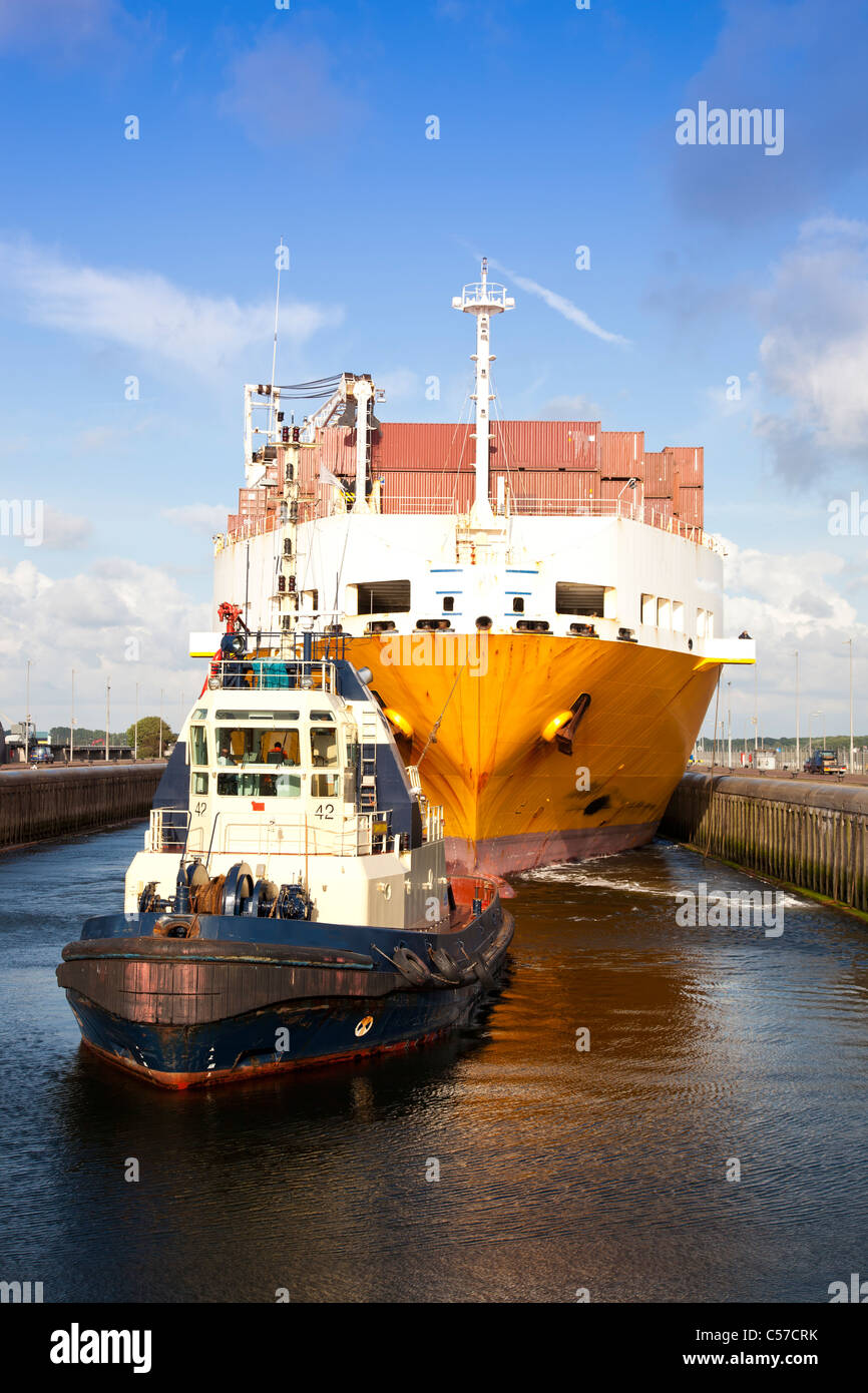 Riesige Containerschiff mit Schlepper im Schloss Stockfoto