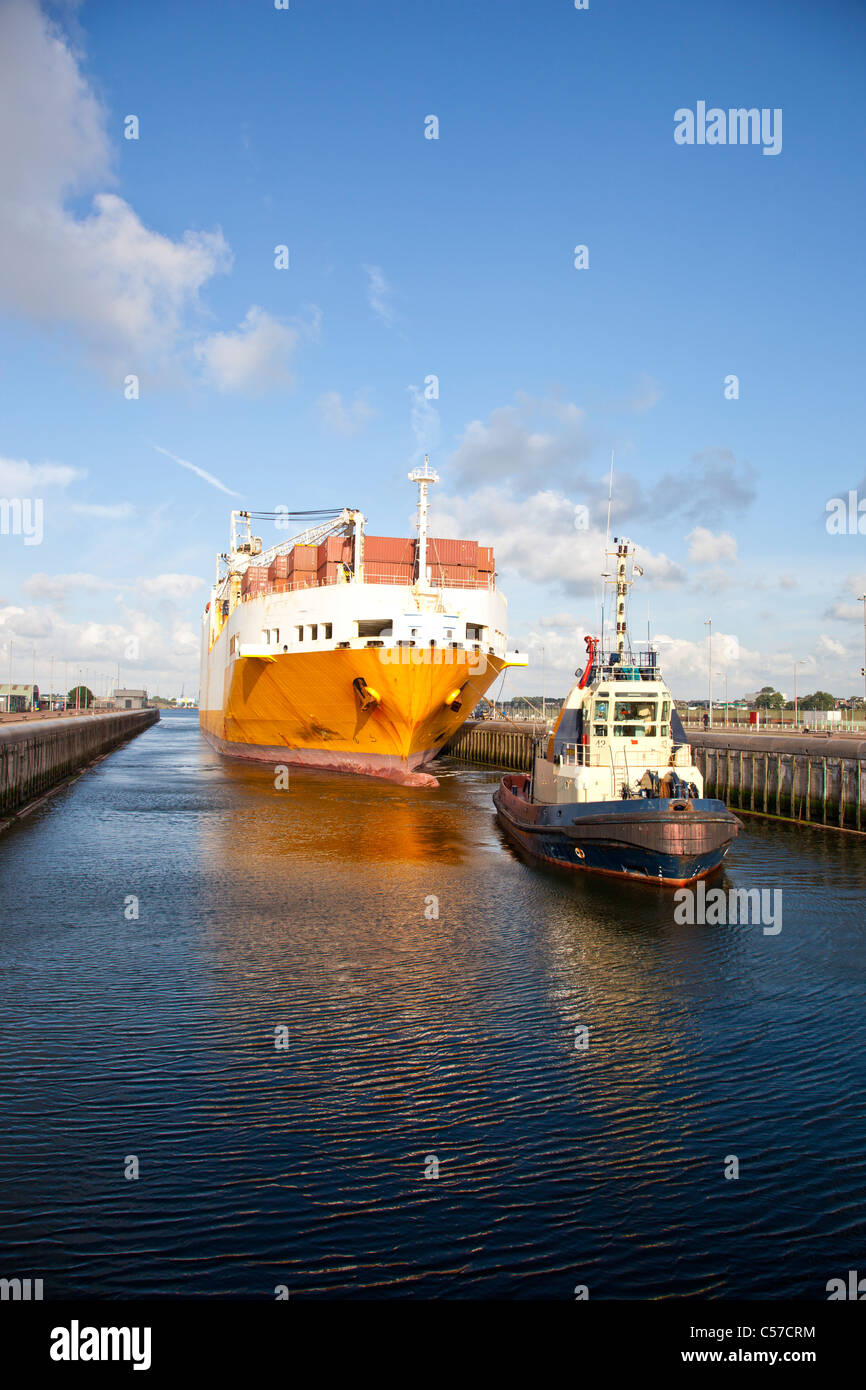 Riesige Containerschiff mit Schlepper im Schloss Stockfoto