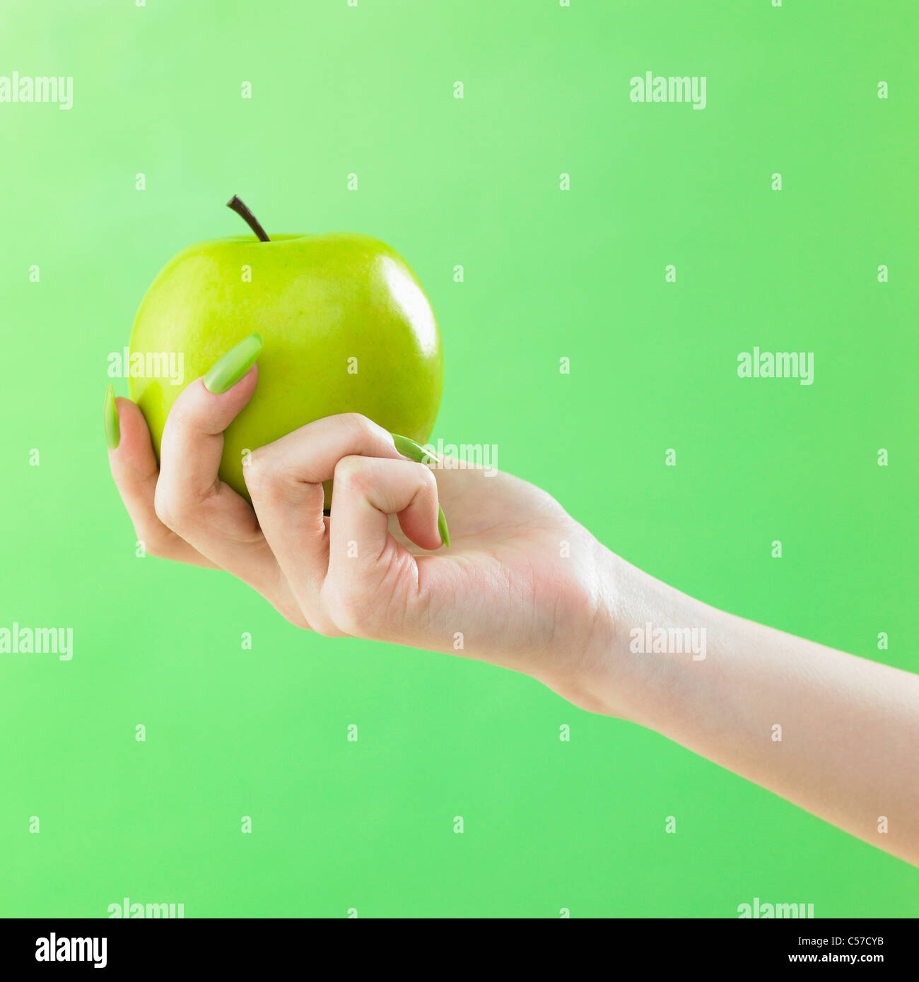grünen farbigen Nagel Hände ergreifen den grünen Apfel Stockfoto