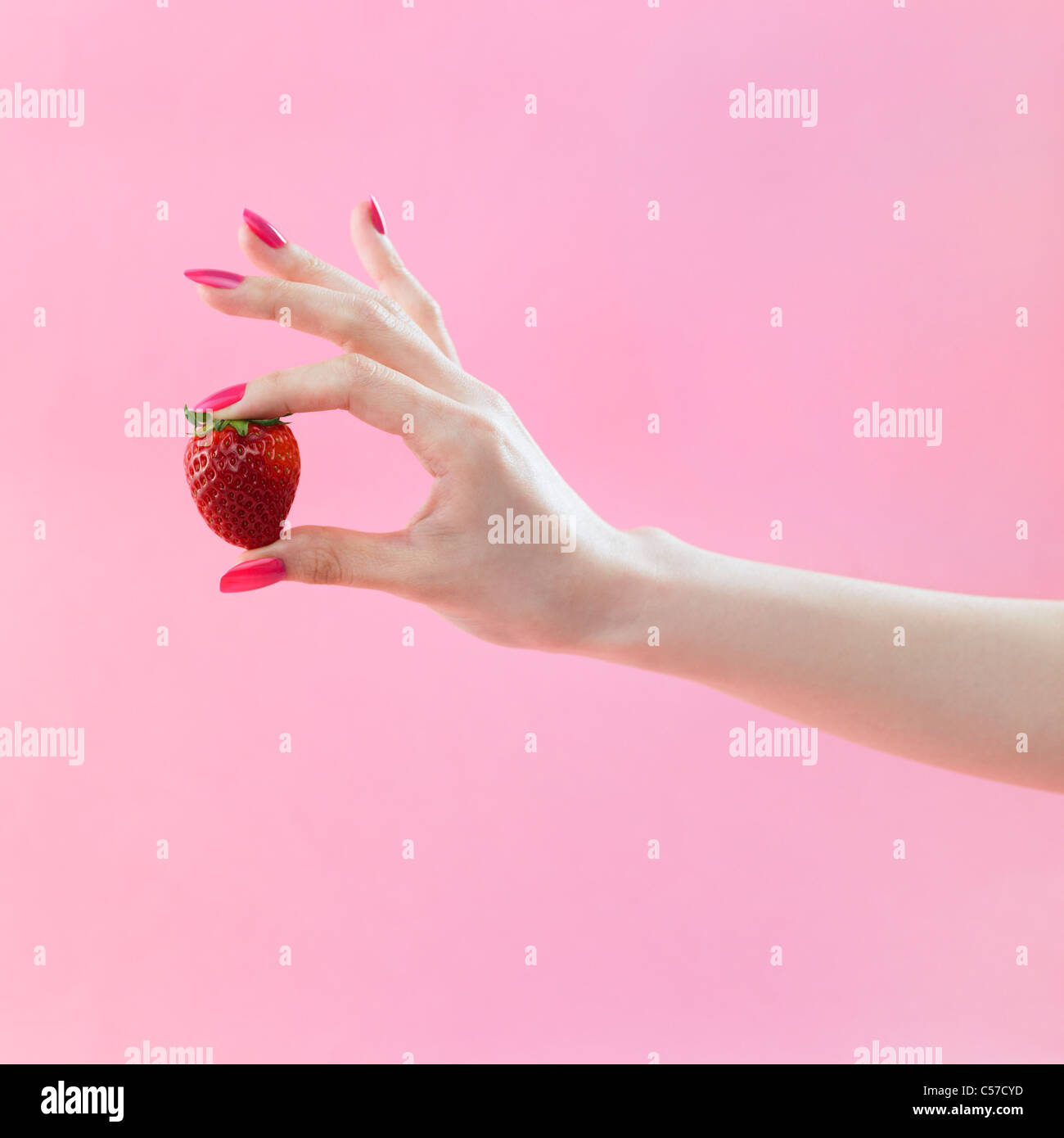 roten farbigen Nagel Hand greifen die Erdbeere Stockfoto
