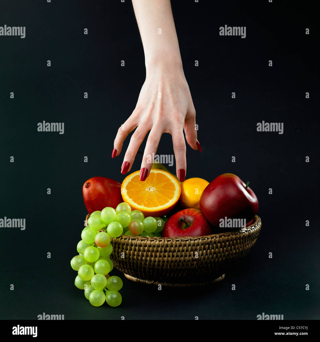 anschauliche farbige Früchte und rot gefärbt Nagel Hände Stockfoto