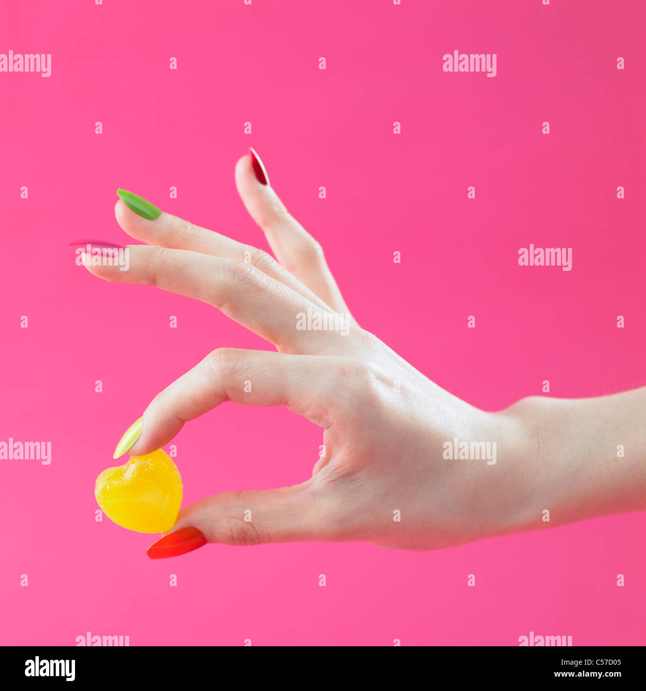 anschauliche farbige Nagel Hand Griff gelbe Süßigkeiten Stockfoto