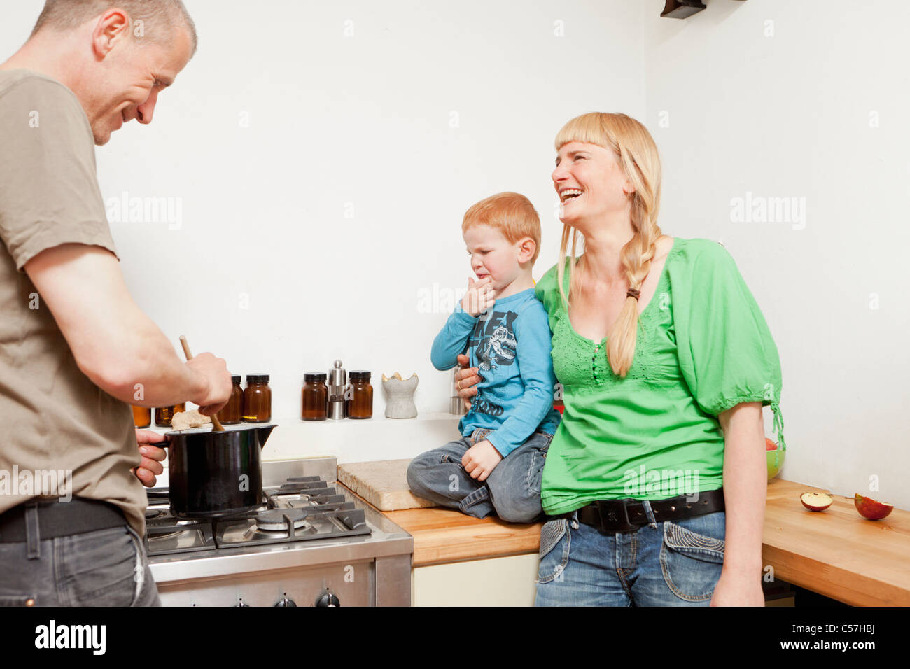 Eltern kochen für nur ungern Sohn Stockfoto