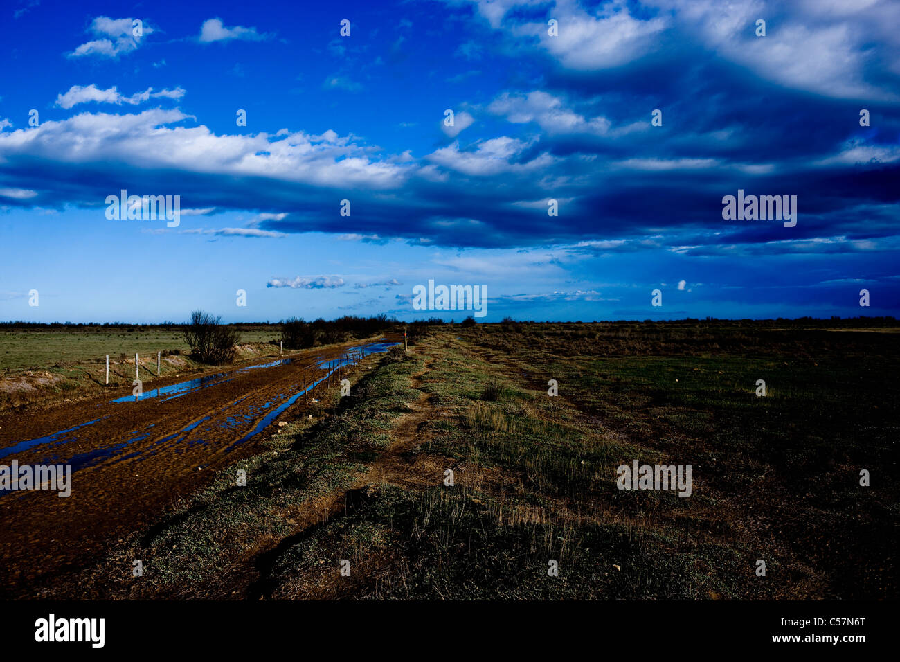 Schlammigen Feldweg unter blauem Himmel Stockfoto