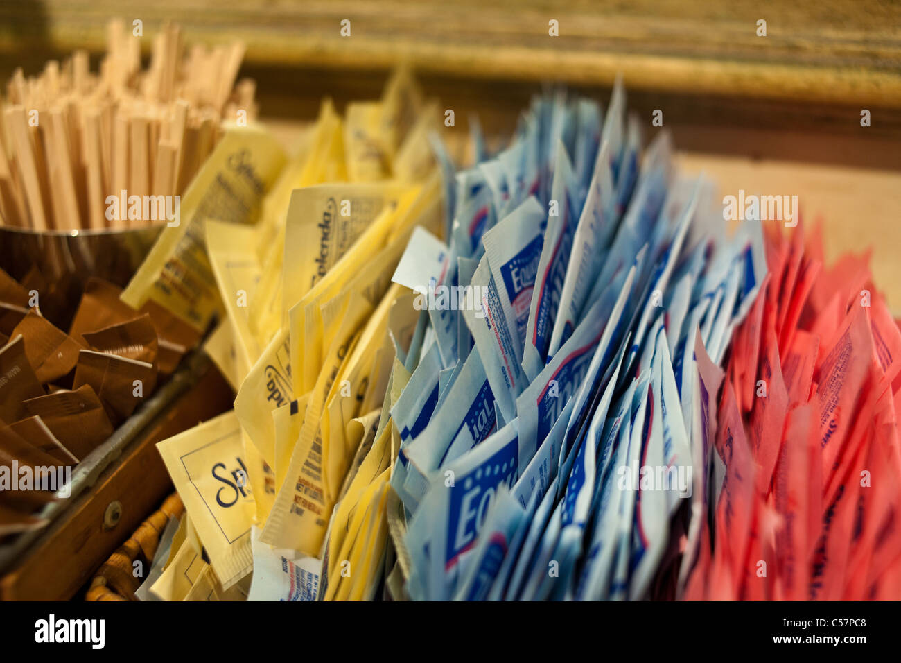 Pakete von Sweet N' Low, Equal, und Splenda und Rohzucker auf einer Theke in einem Café Stockfoto