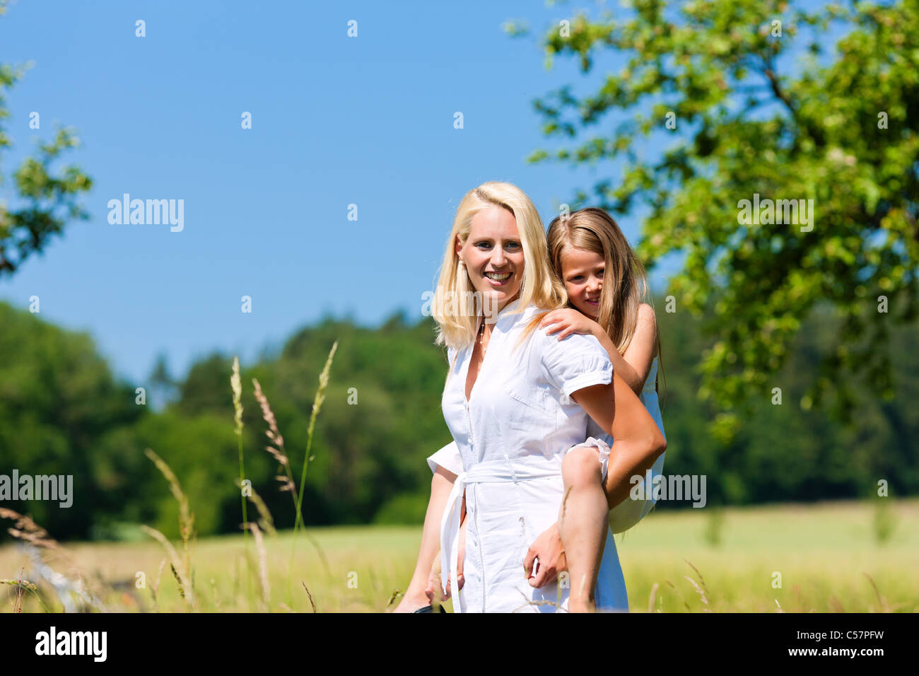 Mutter spielt mit Tochter auf Wiese an einem Sommertag Stockfoto