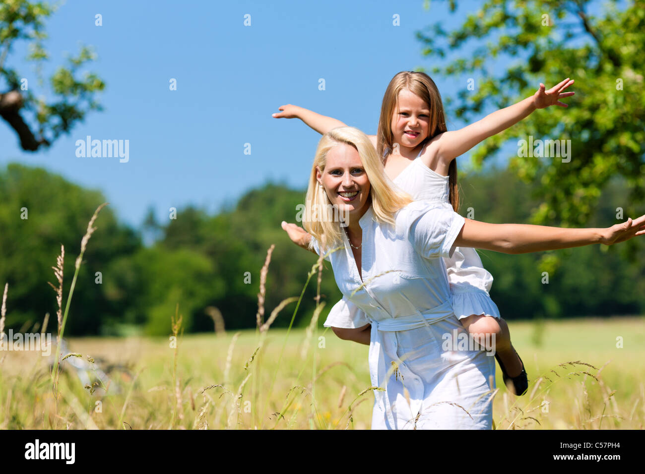 Mutter spielt mit Tochter auf Wiese an einem Sommertag Stockfoto