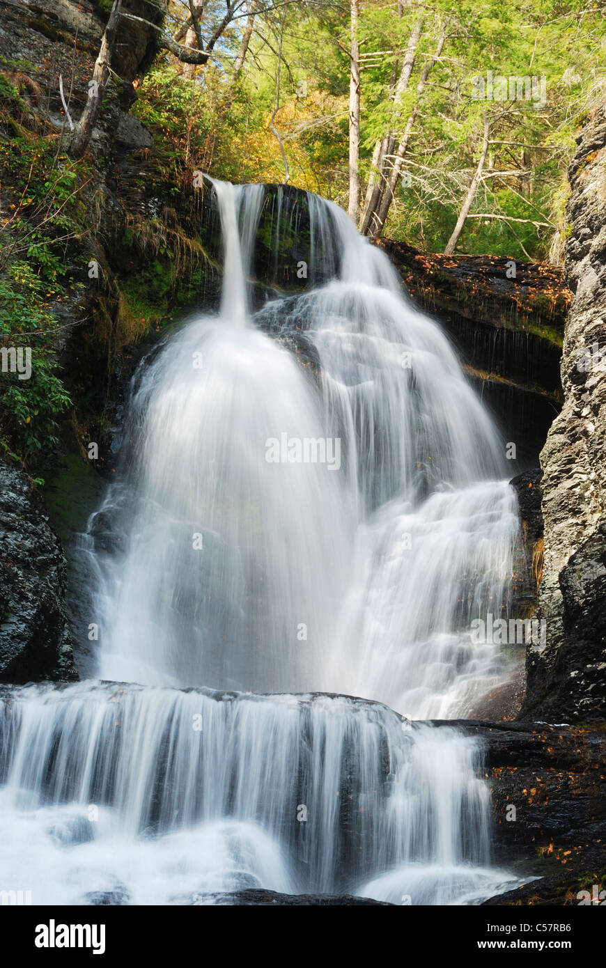 Wasserfall in den Bergen mit Herbstlaub und Wäldern über Felsen. Stockfoto