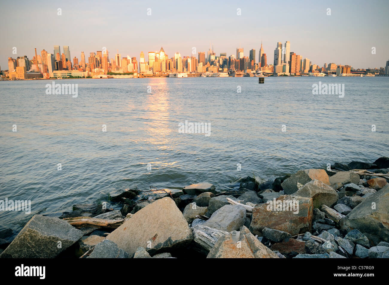 New York City Manhattan Midtown Skyline bei Sonnenuntergang mit Reflexion über Wolkenkratzer und Fluss betrachtet aus New Jersey Hudson River Stockfoto