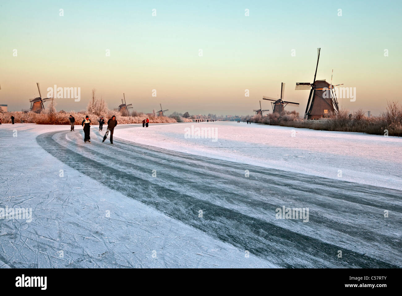 Die Niederlande, Kinderdijk, Windmühlen, UNESCO-Weltkulturerbe. Menschen Eislaufen. Stockfoto