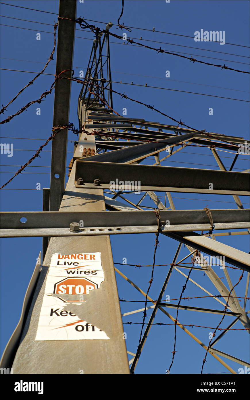 Close-up erschossen von der Basis aus einem Hydro-Turm mit Stacheldraht nachschlagen und Warnzeichen. Stockfoto