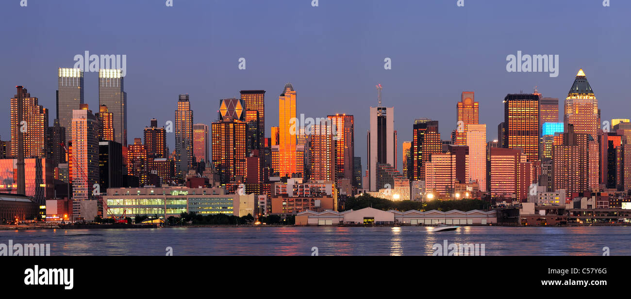 New York City Manhattan Sonnenuntergang Panorama mit historischen Wolkenkratzern über Hudson River mit schönen roten Farbe Sonnenschein Reflexion von New Jersey Weehawken Waterfront angesehen. Stockfoto