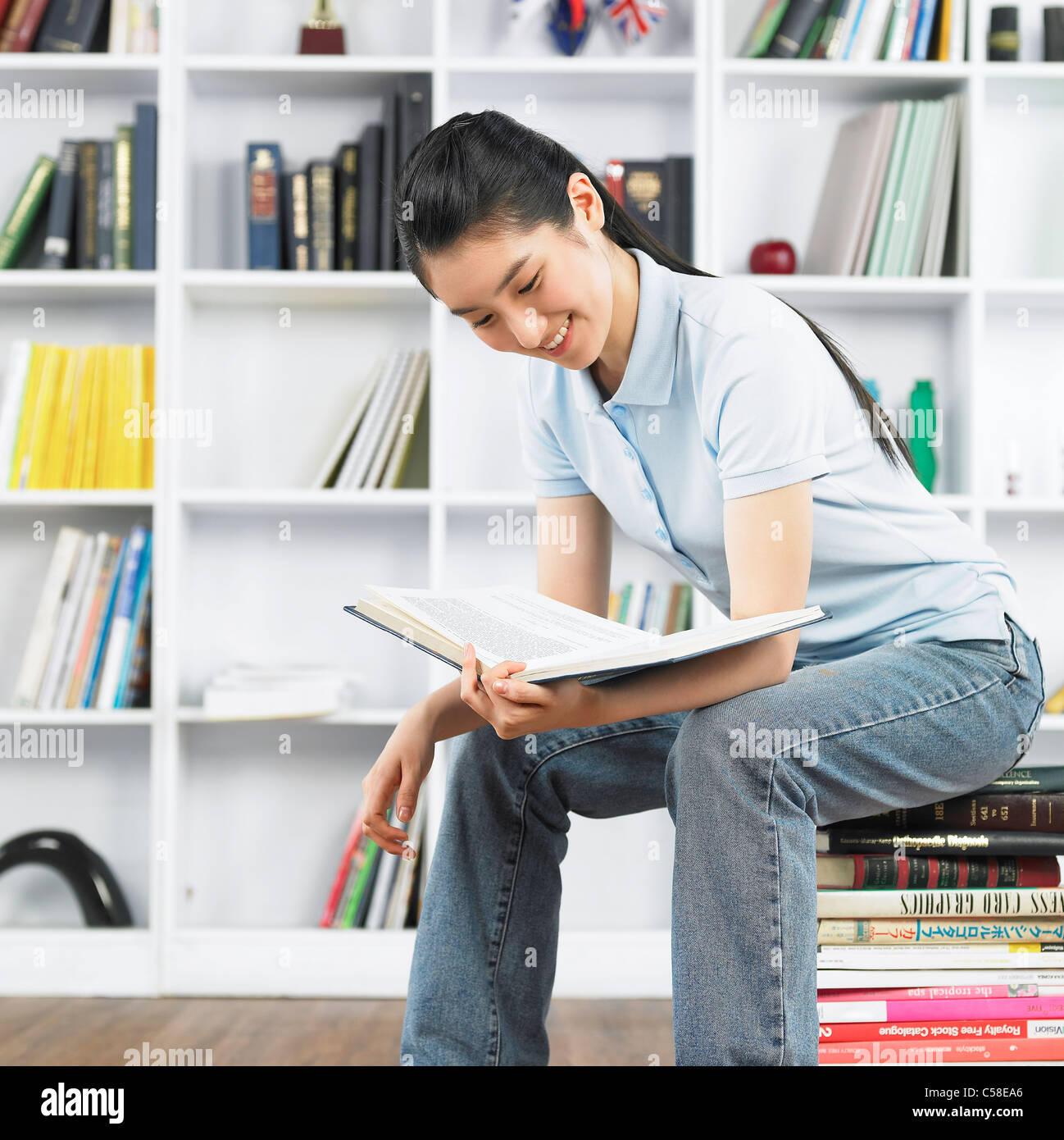 Nahaufnahme von Teenager-Mädchen sitzen auf Bücher Stockfoto