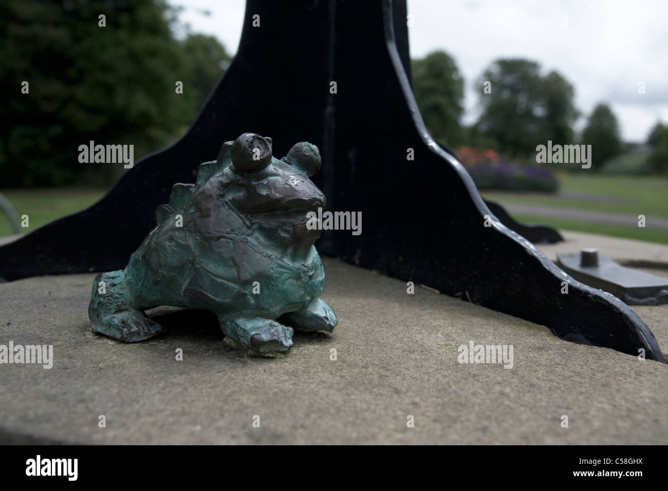 Kröte Detail Skulptur im Victoria Park Newbury Berkshire England UK mit Bäumen und Blumen im Hintergrund Stockfoto