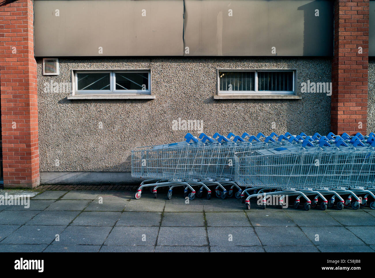 Einkaufswagen Kiesel gestrichelte Wand Witwen und Mauerwerk vor einem Supermarkt in der Stadt WIcklow, Irland. Stockfoto