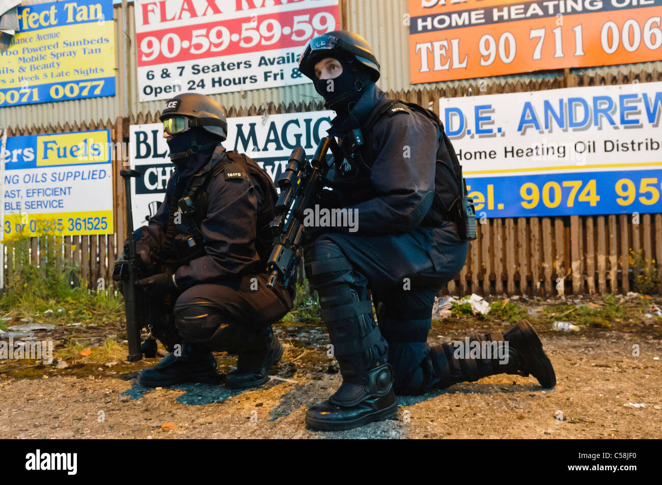 Polizisten in ballistische Ausrüstung bewaffnet mit einem automatischen Maschinengewehr Heckler & Koch G36C und ein L104A1 Stöckchen Runde (Kunststoff Kugel) Pistole Stockfoto