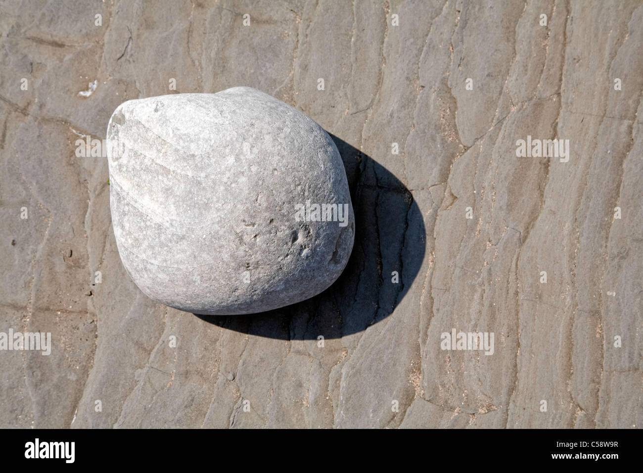 Kleiner Felsen Gießen Schatten auf Platte aus Schiefer in der Nähe von Kilve Strand Stockfoto