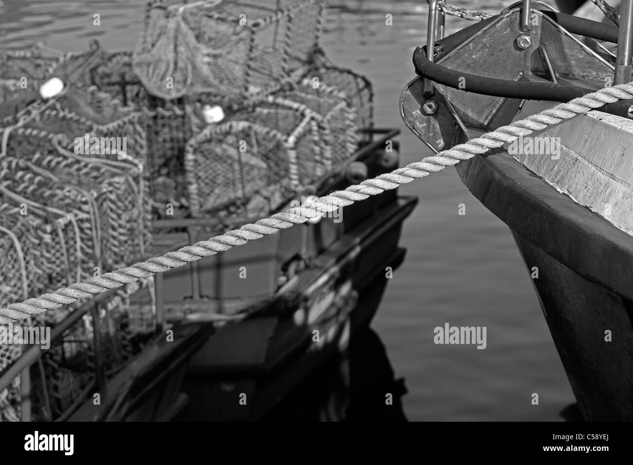 Schwarz-weiß-Bild der Szene in Hout Bay Hafen mit einem Boot, Seile und Krebse Töpfe. Stockfoto