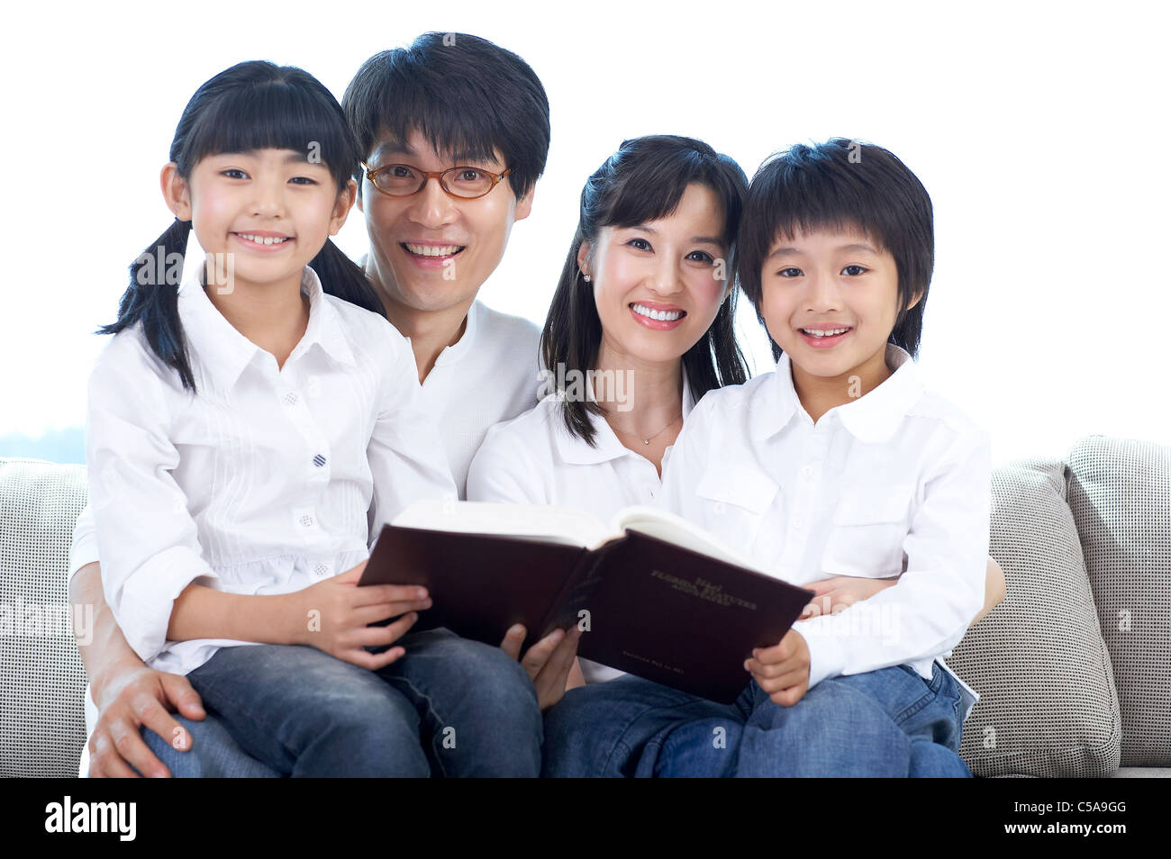 Mutter und Vater mit Sohn und Tochter Buch lesen Stockfoto