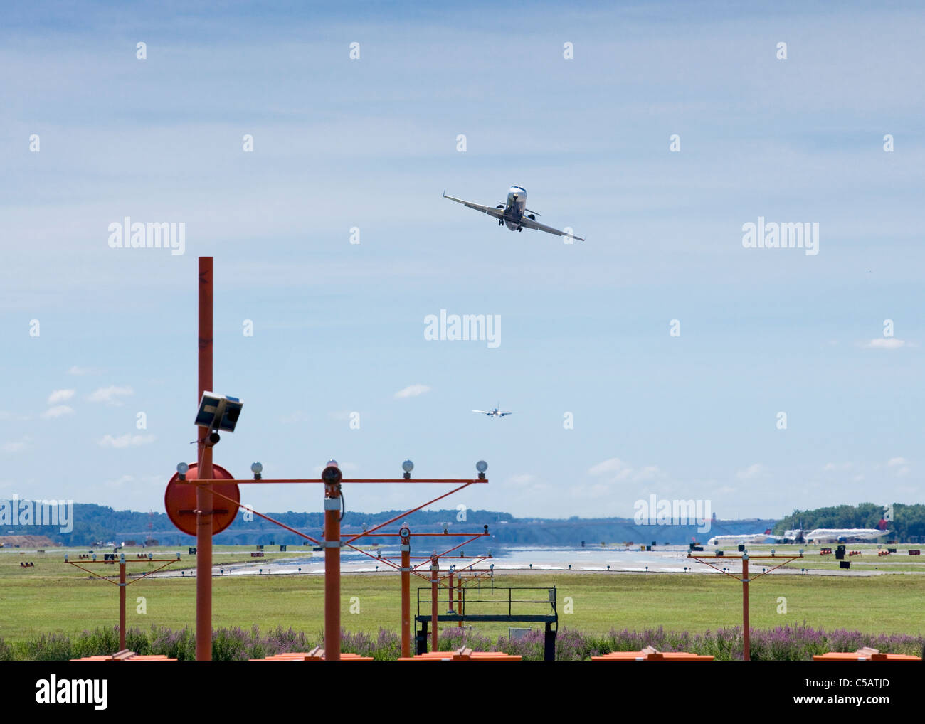 Ein Pendler-Jet zieht über PAPI Lichter am Ende der Start-und Landebahn Stockfoto