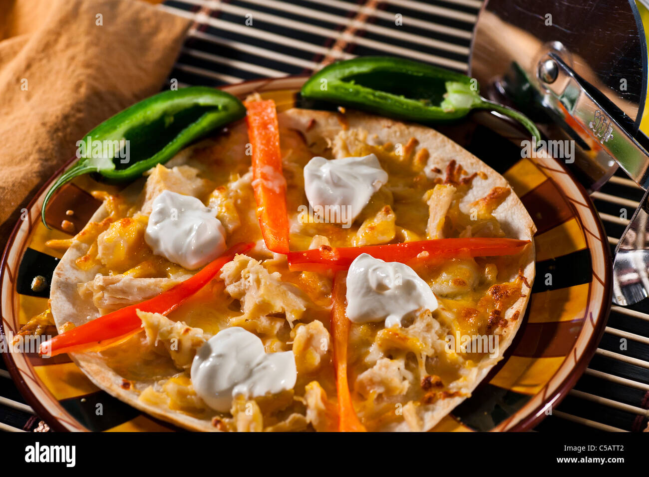 Frische Weizentortilla mit Cheddar-Käse, Huhn Brocken und süße Paprika bedeckt. Stockfoto