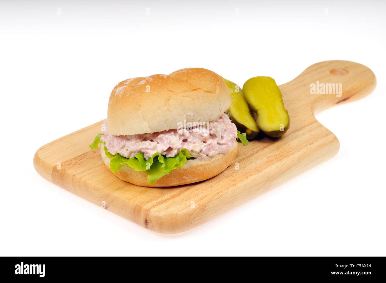 Schinken, Salat mit Mayo & Salat Sandwich in einem weißen Brötchen mit Dill Pickles auf einem Holz Schneidebrett auf weißem Hintergrund ausschneiden. Stockfoto