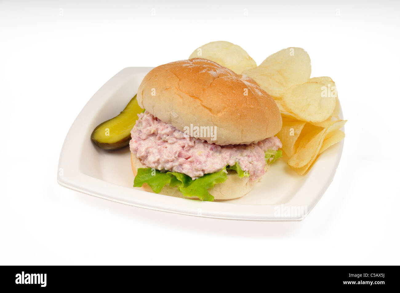 Ham salad Sandwich mit Mayo & Salat in einer Rolle mit Kartoffelchips und eine Essiggurke in Weiß Fach auf weißem Hintergrund, ausgeschnitten. Stockfoto