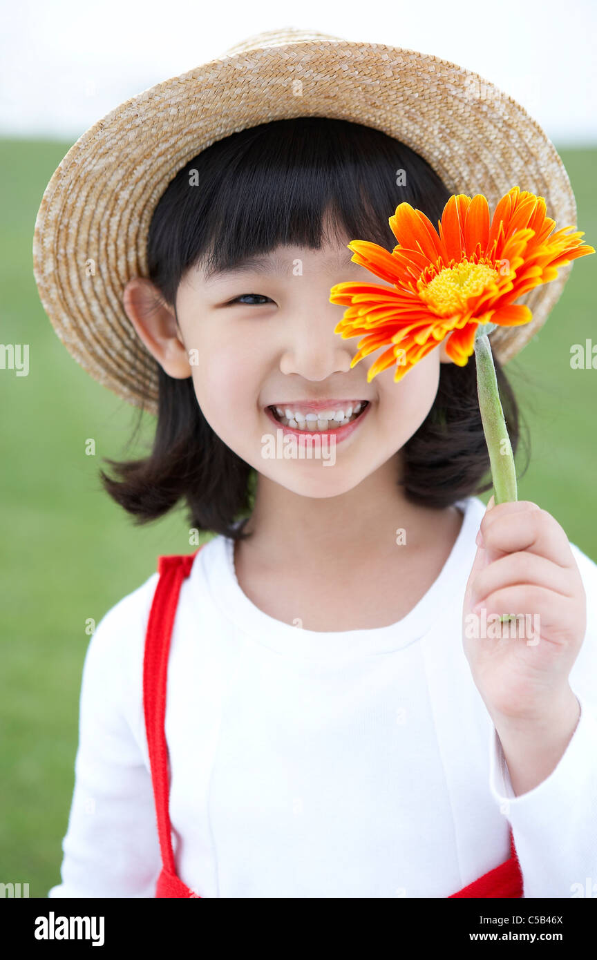 Porträt von Mädchen Holding Blume in Rasen Stockfoto