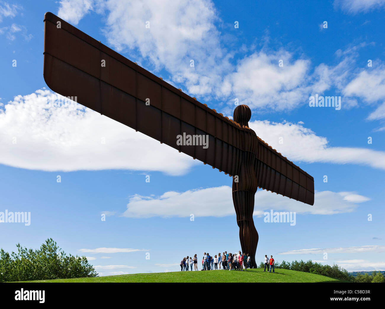 Touristen unter der Engel des Nordens-Skulptur von Antony Gormley, Gateshead, Tyne and Wear, North East England, UK Stockfoto