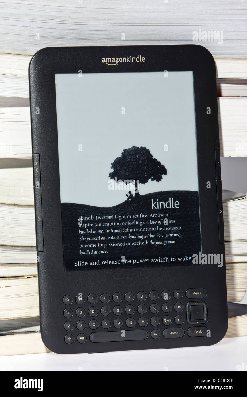 Amazon Kindle e-Reader neben einer unordentlichen Haufen traditionelle Bücher Stockfoto