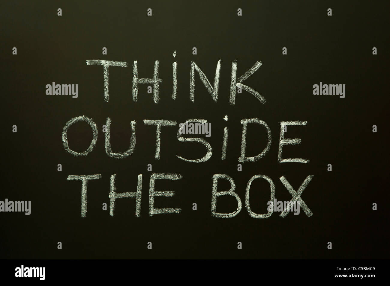 Konzept-Bild über das unkonventionelle oder anders denken. "Think outside the Box" handschriftlich mit weißer Kreide auf eine Tafel. Stockfoto