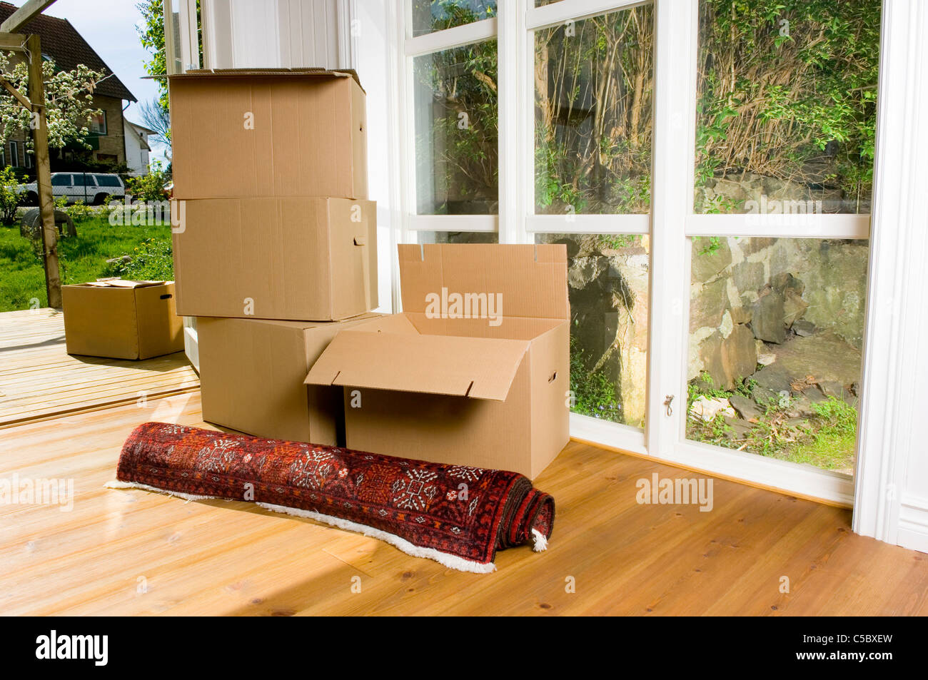 Stapeln von Umzugskartons und Teppich auf Holzboden an der Tür  Stockfotografie - Alamy
