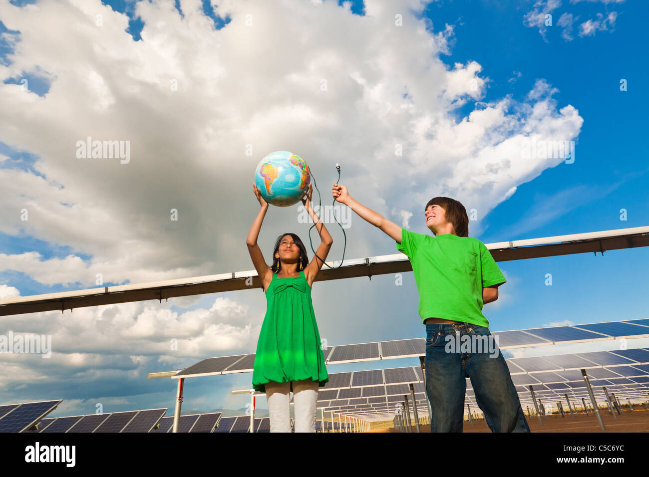 Kinder halten Globus in der Nähe von Sonnenkollektoren Stockfoto