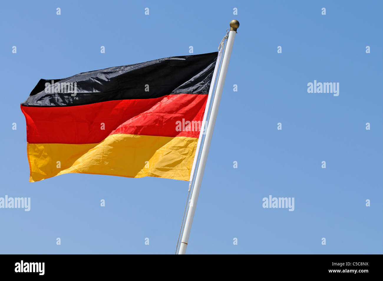Deutsche Flagge im Wind am blauen Himmelshintergrund Stockfoto