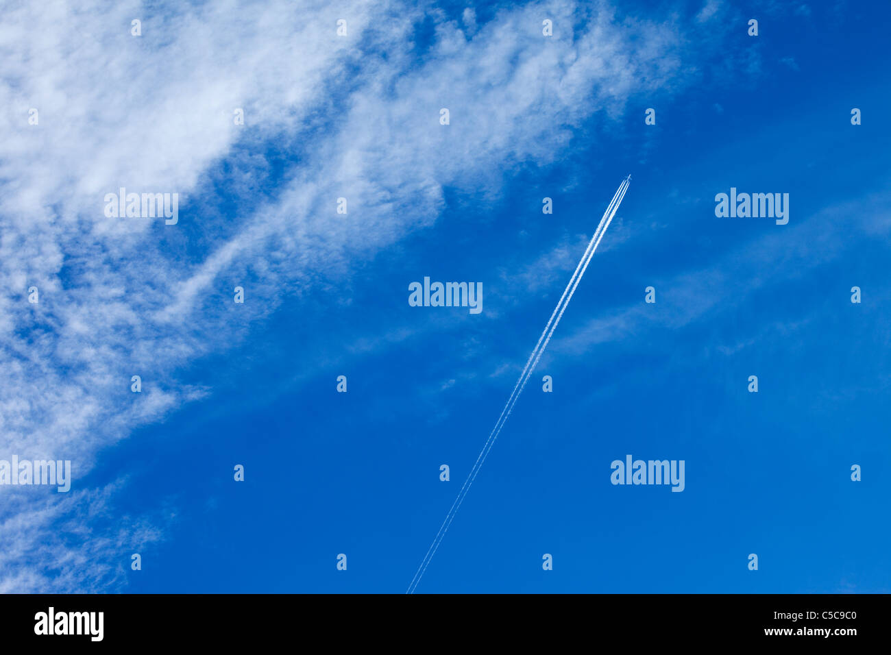 Ein Passagierflugzeug in Großbritannien verlassen Kondensstreifen gegen ein blauer Himmel und hohen Wolke Stockfoto