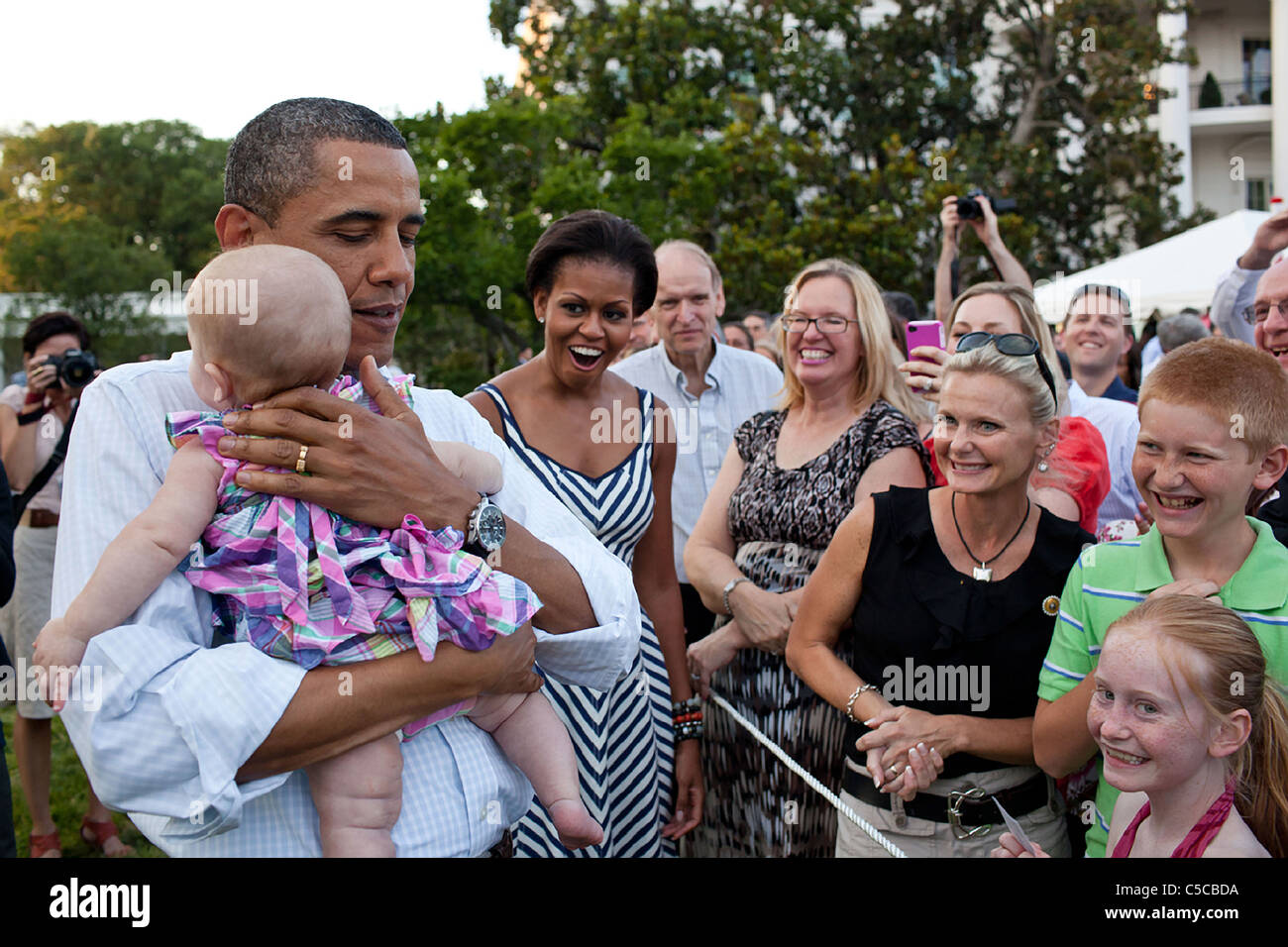 First Lady Michelle Obama reagiert wie Präsident Barack Obama ein schreiendes Baby beruhigt Stockfoto