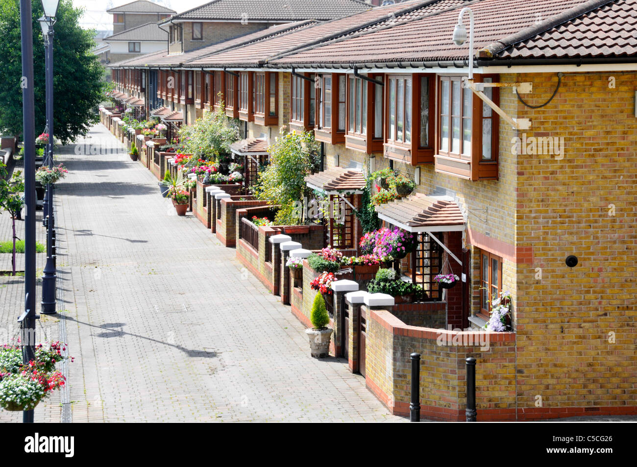 Moderne Reihenhäuser in East London mit kleinen Garten auf breiter Kanal Seite Fußgängerweg England Großbritannien Stockfoto