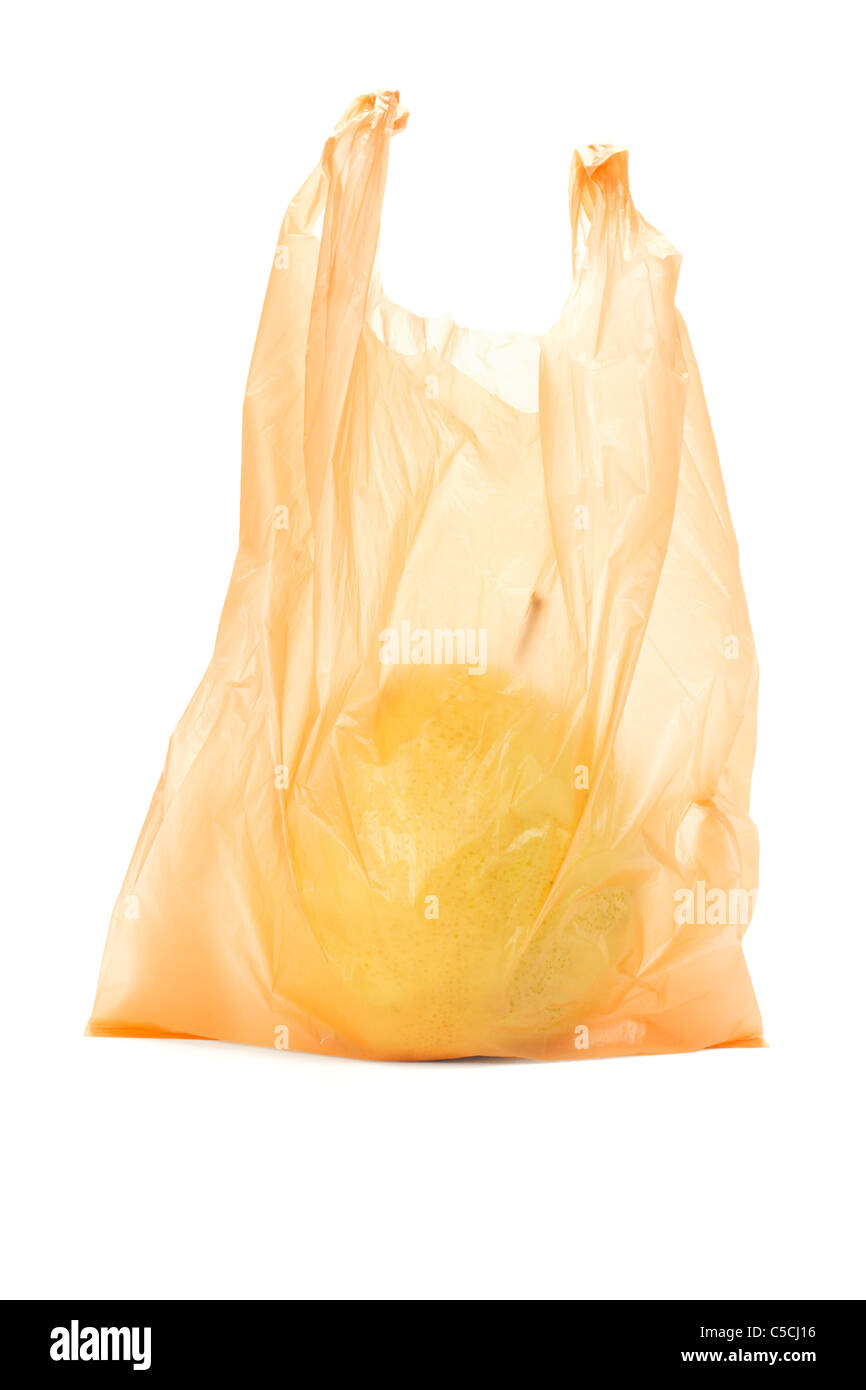 Gelbe Birne in orange Plastiktüte auf weißem Hintergrund Stockfoto